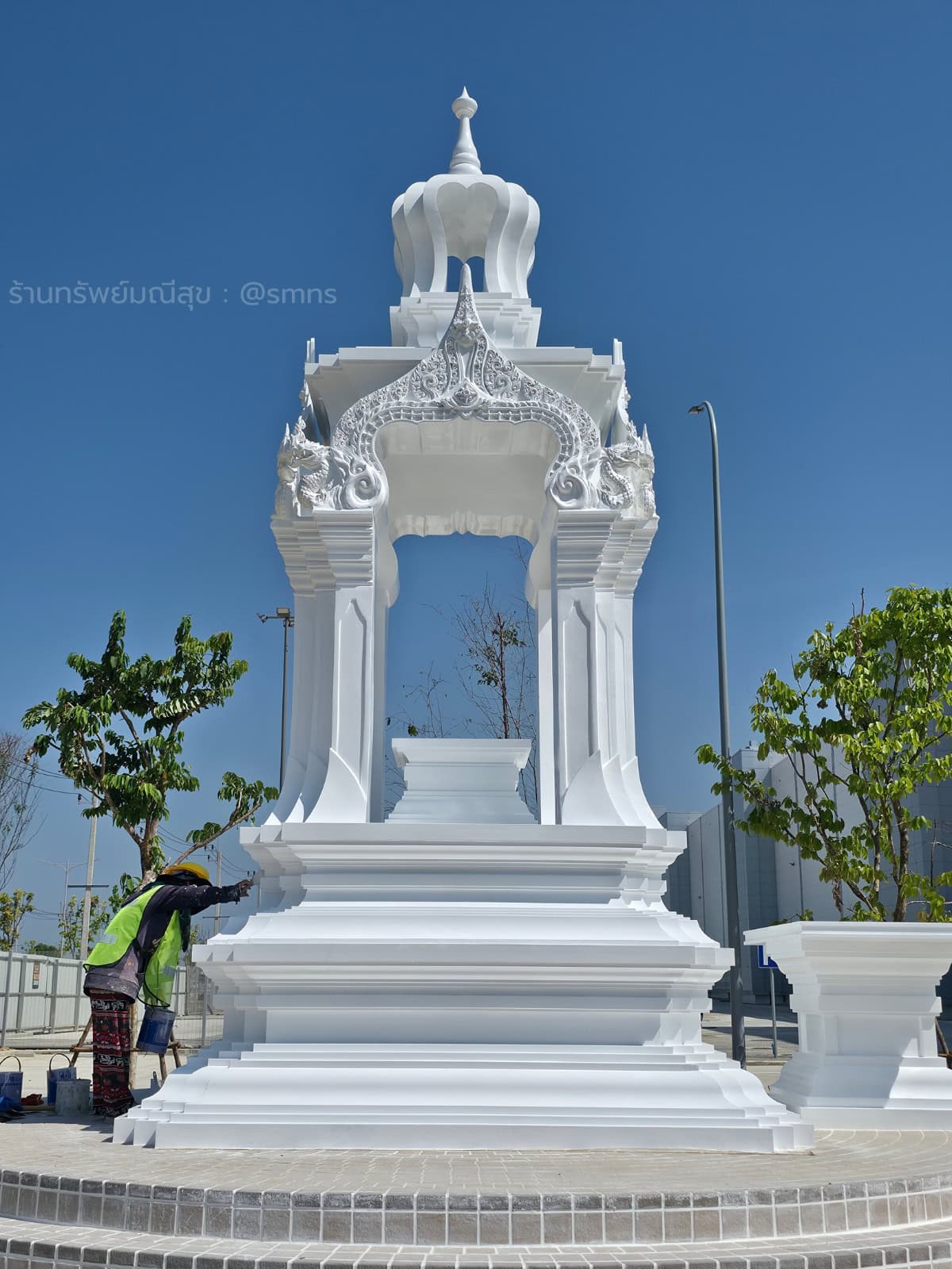 ทีมงานอยู่ข้างฐานศาลพระพรหม Infineon ภาพเต็มศาลแสดงสัดส่วนเทียบกับคน