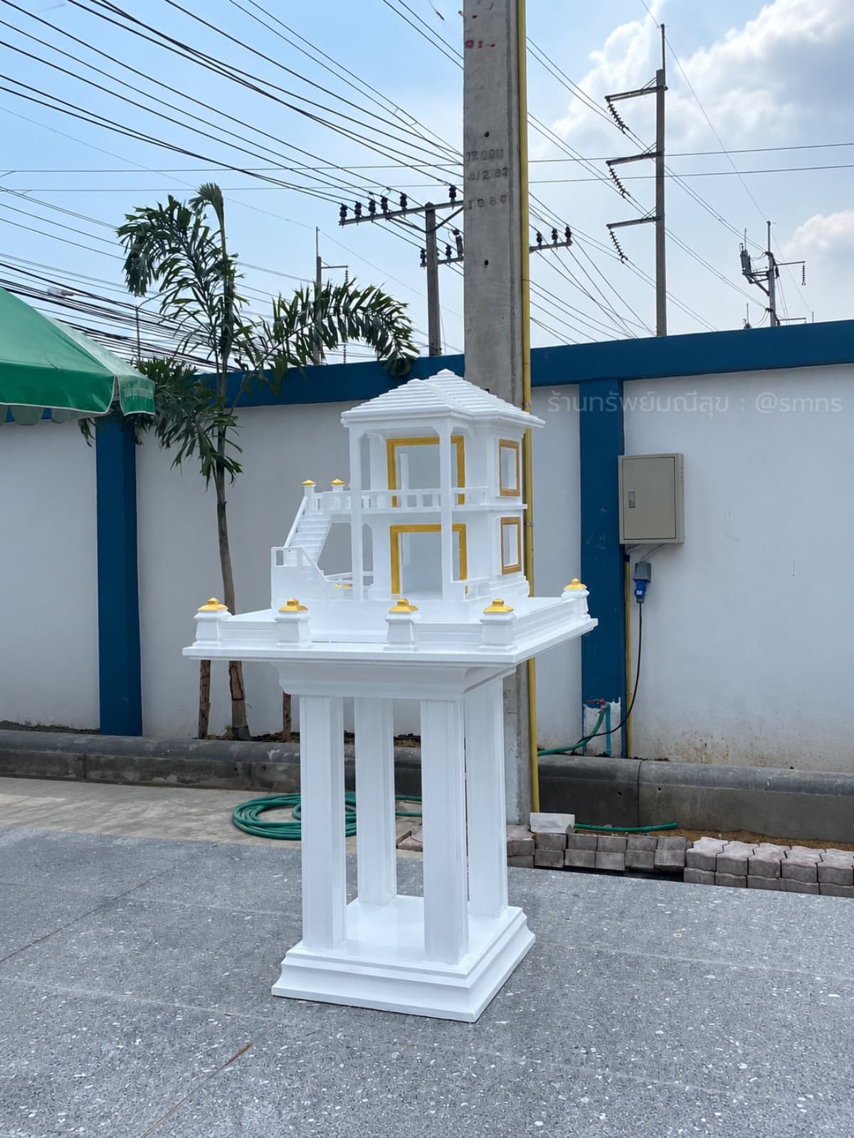 ภาพเต็มศาลตายาย MDJ-0008 สีขาวทองมุมเฉียงบนลานคอนกรีต เห็นฐานรองและหลังคา