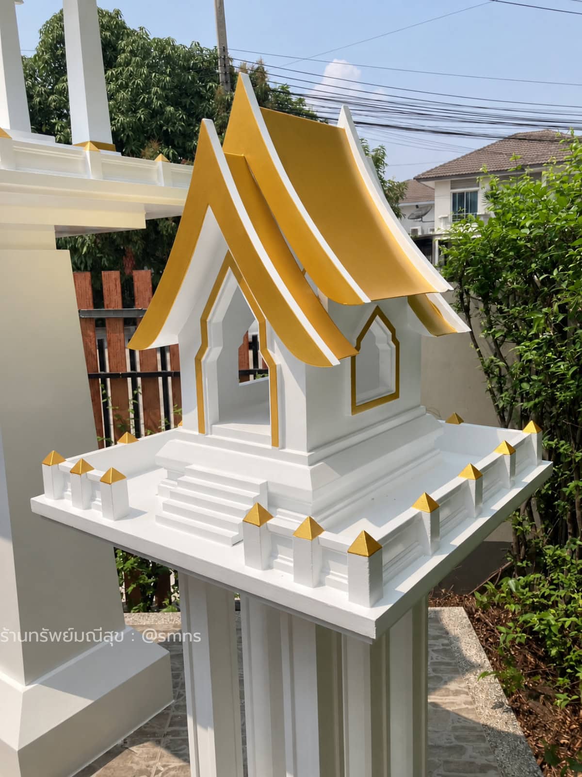 ภาพระยะใกล้ศาลตายาย MDJ-0021 สีขาวตัดทอง แสดงหลังคาไทยประยุกต์ ประตูด้านหน้า หน้าต่างด้านข้าง และรั้วรอบจานศาล