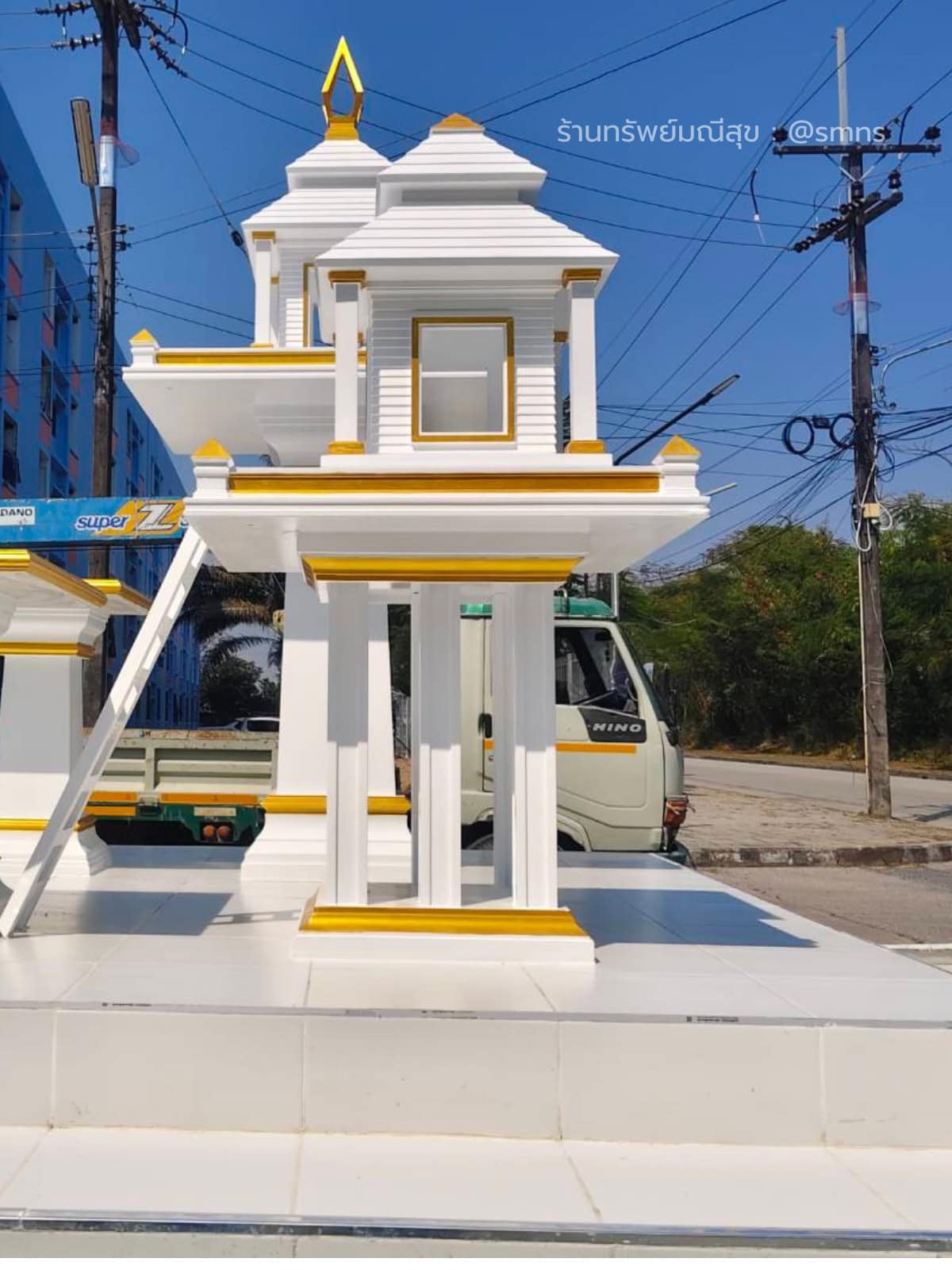 ศาลตายาย MDJ-0022 สีขาวตัดทอง มุมด้านข้าง เห็นหน้าต่าง ฐานเสา และศาลพระภูมิอยู่ด้านหลัง