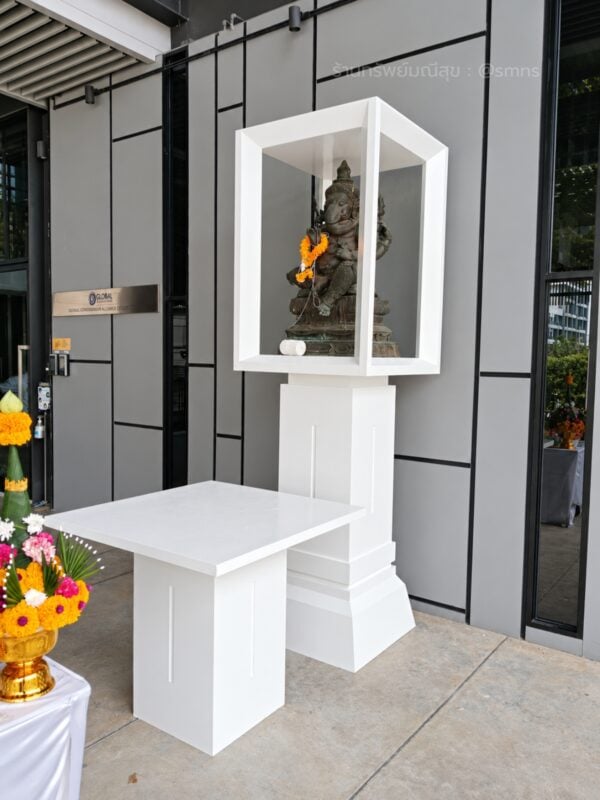 ศาลโมเดิร์น PS-0024 ประดิษฐานองค์พระพิฆเนศ พร้อมโต๊ะสีขาว มุมเฉียงหน้าอาคารสีเทา