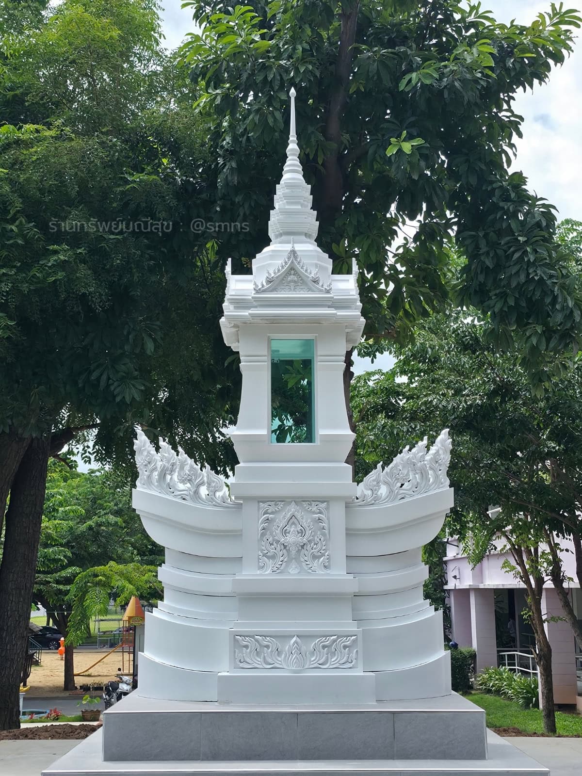 หอพระบรมสารีริกธาตุสีขาว มุมตรงด้านหน้า เห็นส่วนฐานรูปทรงคล้ายเรือ ช่องกระจก และยอดทรงไทย