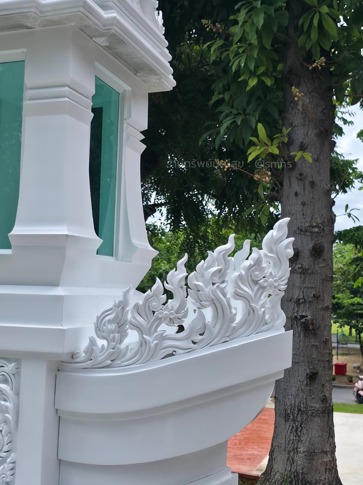 ลายไทยสีขาวประดับเหนือส่วนโค้งคล้ายกราบเรือของหอพระบรมสารีริกธาตุ