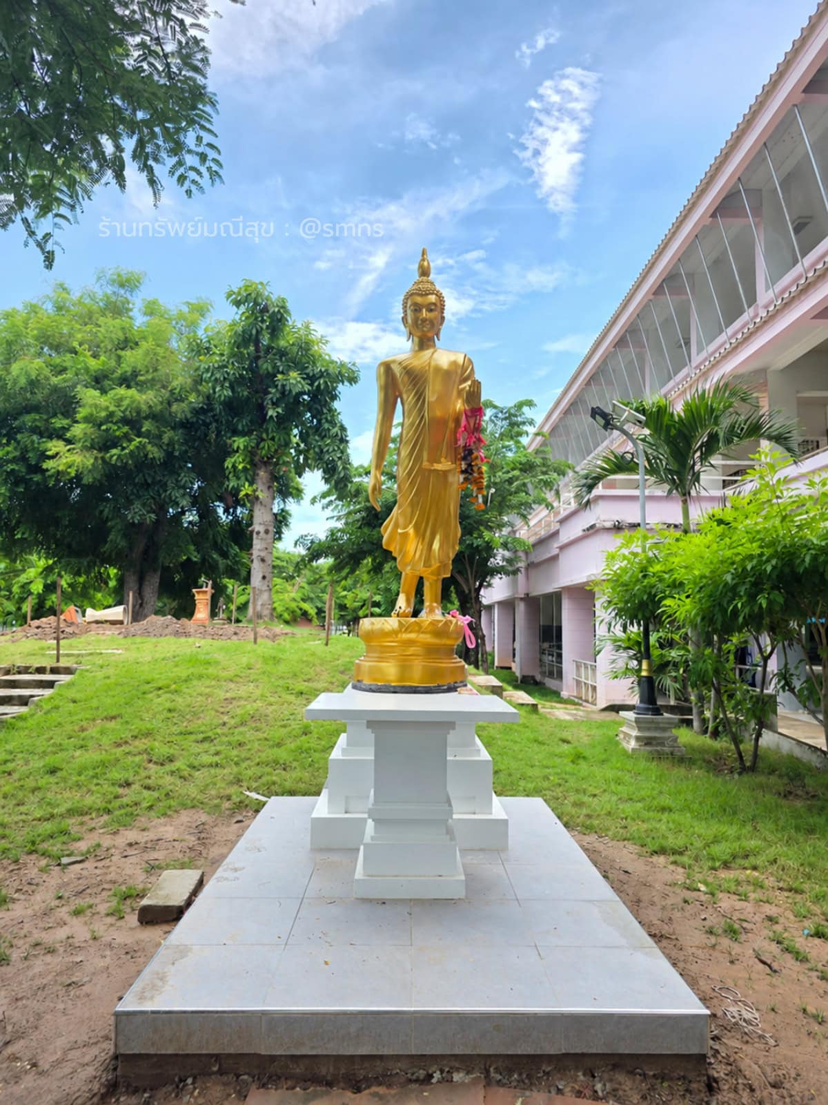 พระพุทธรูปปางประทานพรสีทองประดิษฐานบนฐานสีขาว มุมตรงด้านหน้า โรงเรียนสุพรรณบุรีปัญญานุกูล